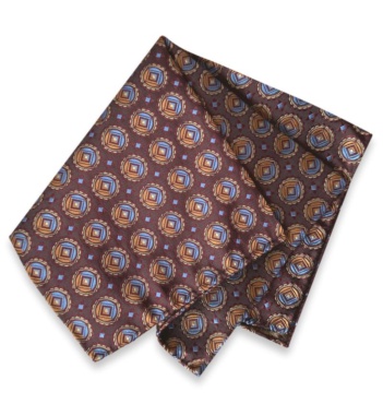 Folded burgundy jacquard silk pocket square with repeating blue and gold medallions