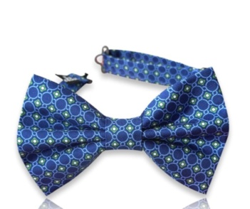 Neven blue silk twill bow tie with light blue circular outlines and green geometric accents on a white background.